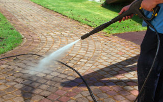 cleaning street with high pressure power washer
