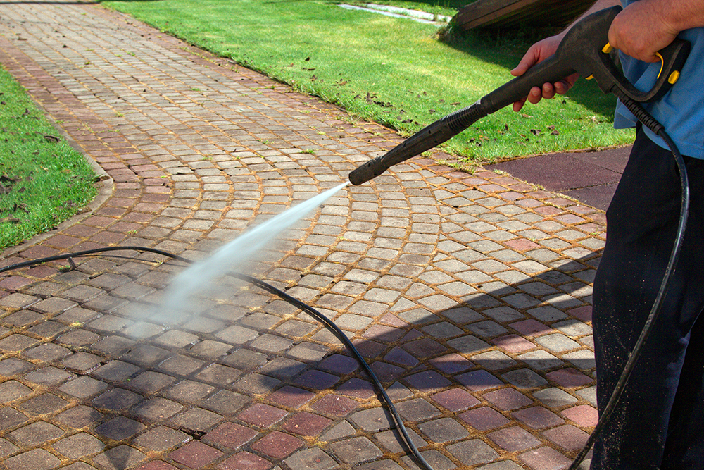 cleaning street with high pressure power washer